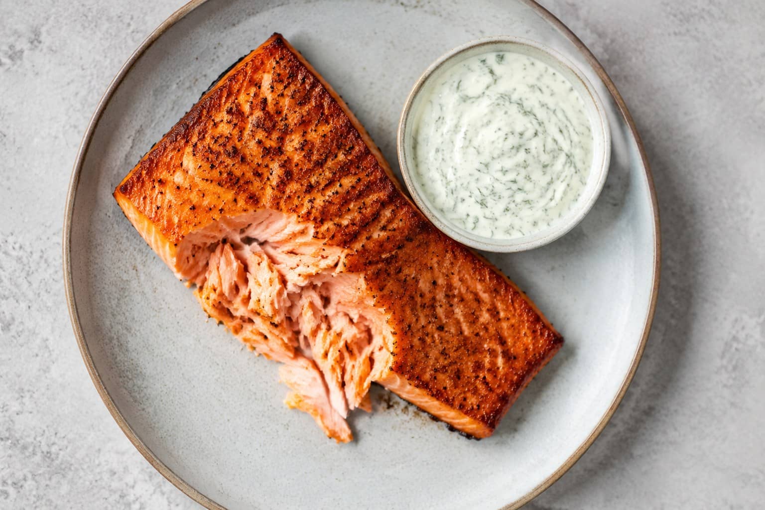 Grillet laksefilet med sprødt skind og grøn dildcreme serveret med citronbåde