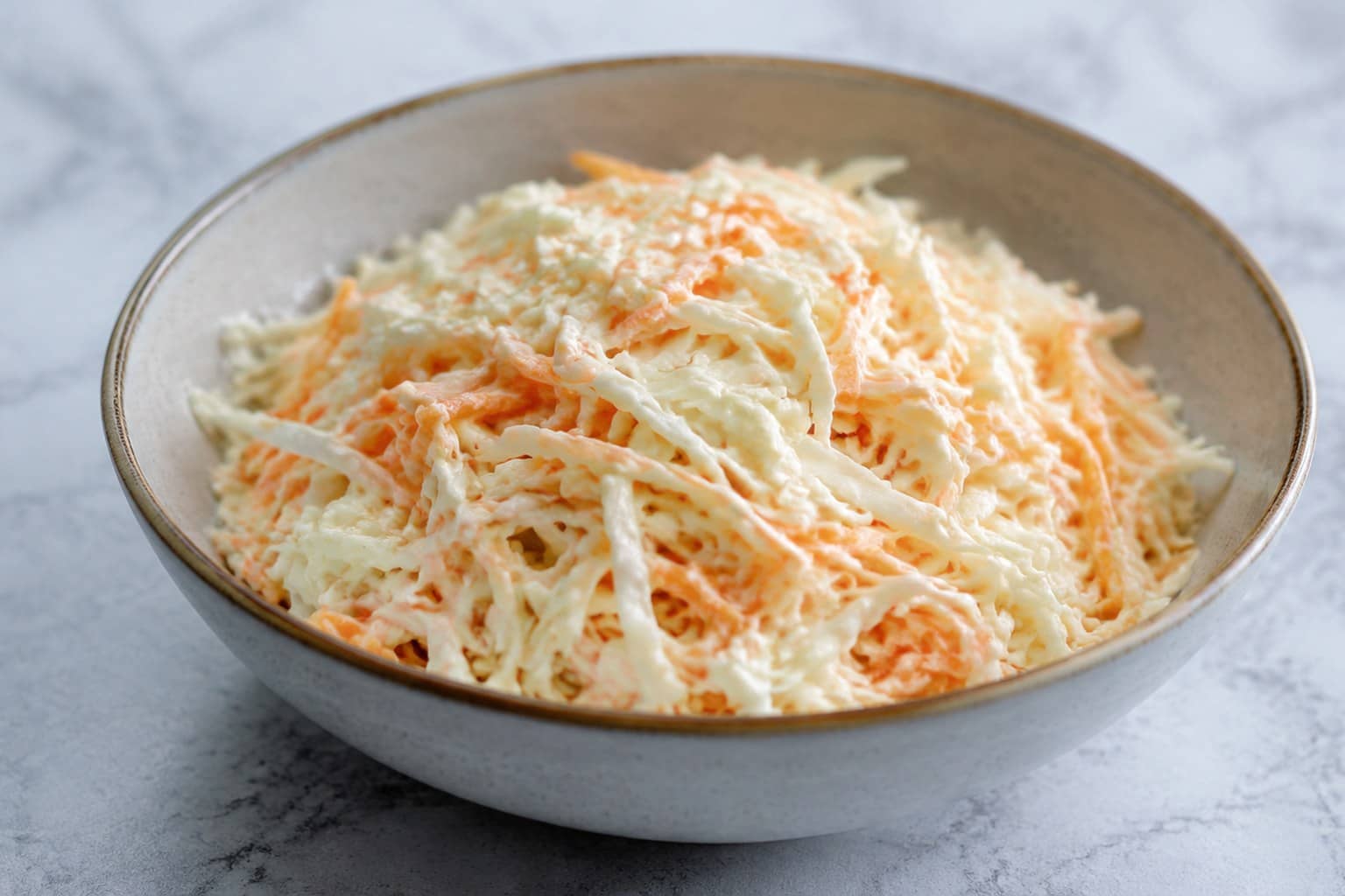 Frisk, cremet coleslaw med hvidkål, gulerod og forårsløg i en skål