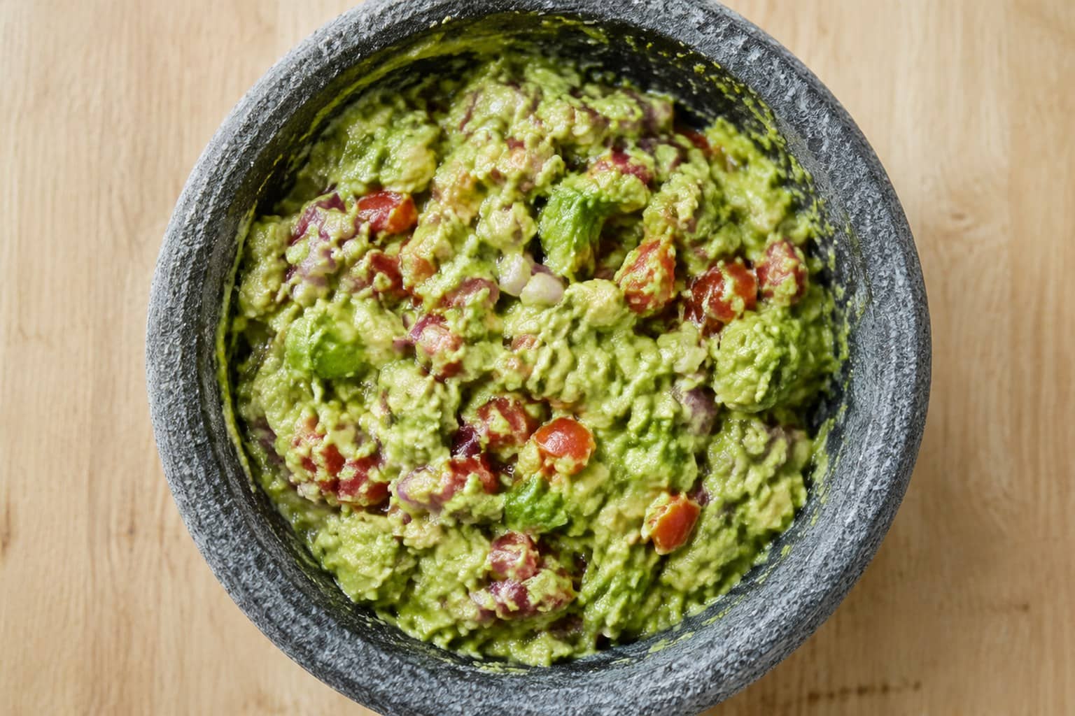 Skål med frisk hjemmelavet guacamole med tomat og rødløg