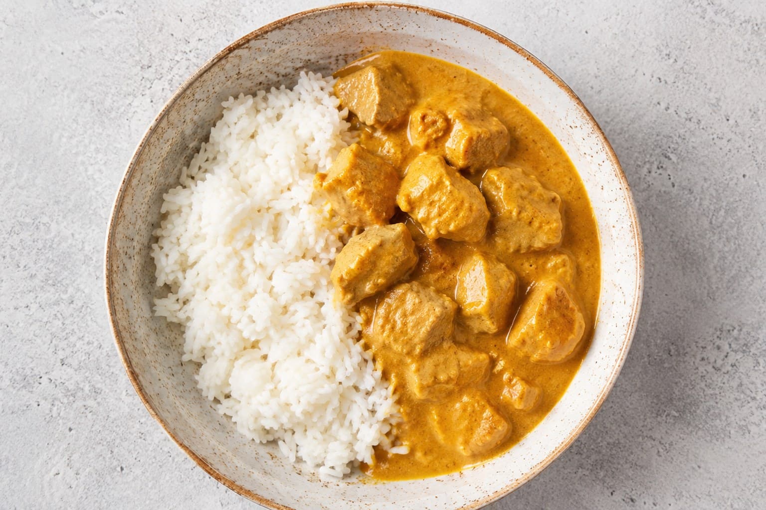 Cremede kylling i karry med æble og banan i gul cremet sauce, serveret med basmatiris