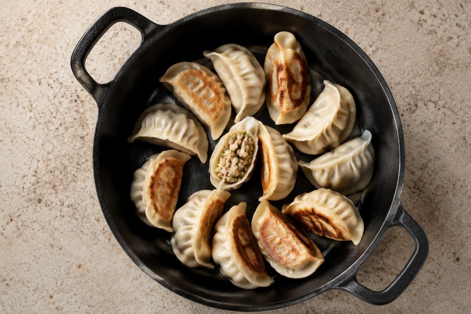 Hjemmelavede gyoza med sprød gylden bund og dampet top på mørk tallerken